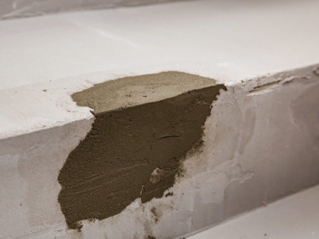 Bostik repair mortar applied to rebuild a damaged concrete step edge, showing layered restoration of the surface.
