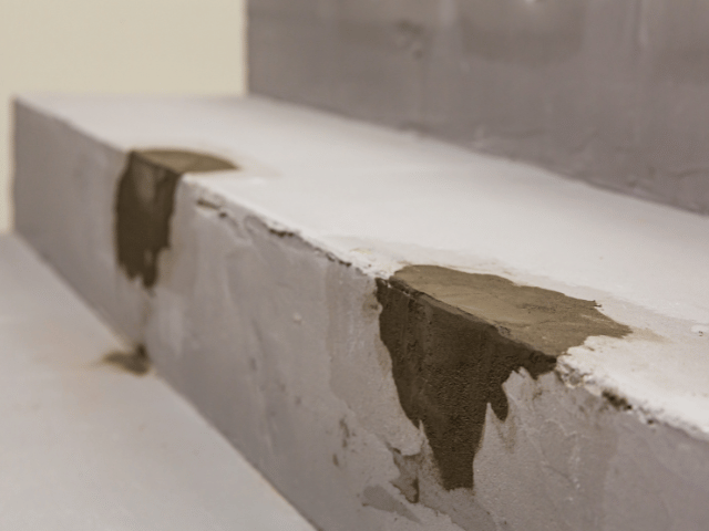 Concrete step edges repaired with Bostik mortar, showing multiple patched areas prepared for final finishing.