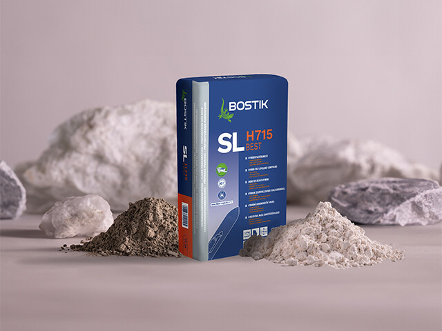 Bag of Bostik SL H715 BEST floor levelling compound placed among mineral powders representing its hybrid cement-gypsum formulation.