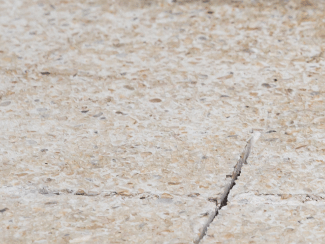 Cracked concrete floor surface with visible intersecting fractures before repair using Bostik RENO system.