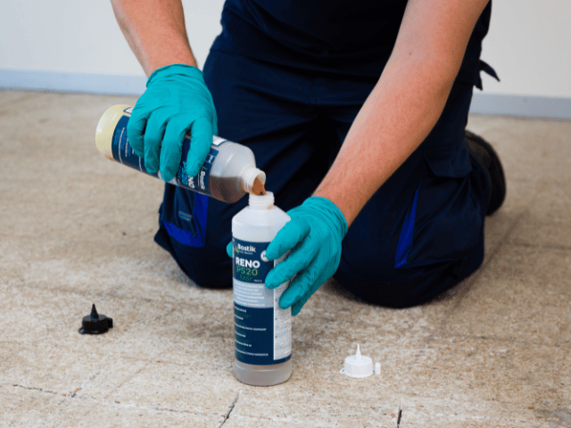 Bostik RENO P520 components being mixed by pouring liquid into a bottle, prepared for concrete floor crack repair application.