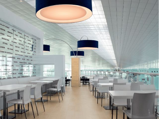 Modern commercial interior with tables, chairs and large pendant lights, illustrating flooring applications using Bostik solutions.