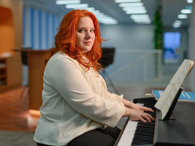 Cecilia sitting at the piano with both hands on the keys