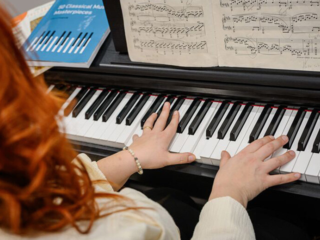 Cecilia playing the piano reading sheet music